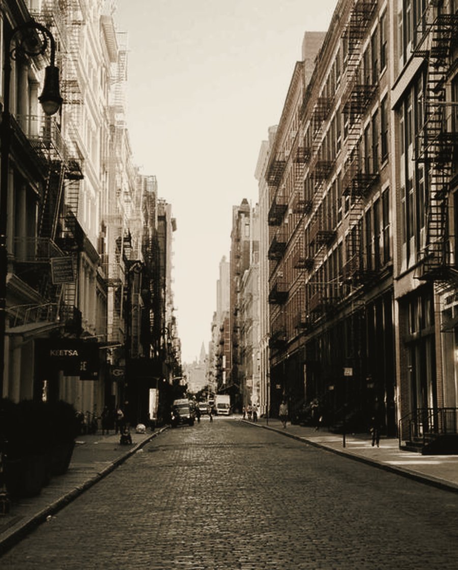 A quiet urban street framed by restored facades receding to a vanishing point.