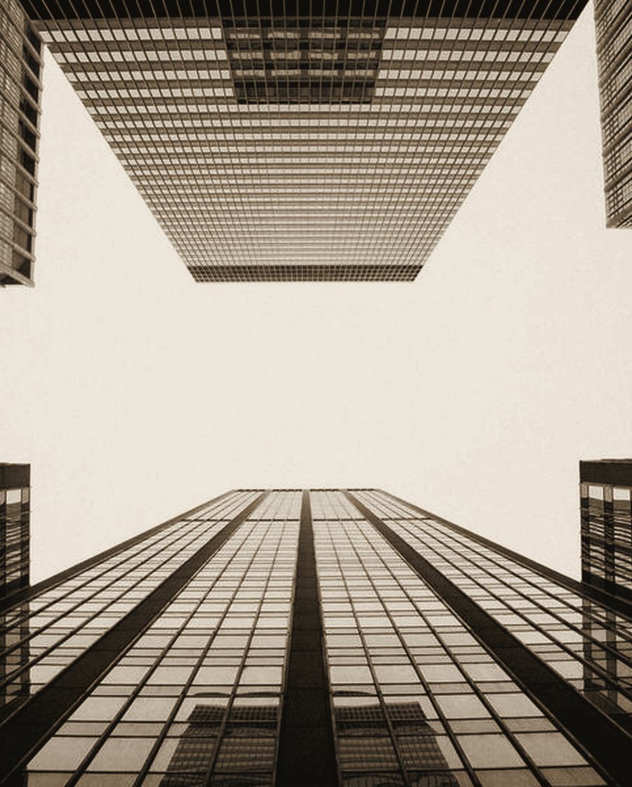 A symmetrical concrete atrium opening to the sky through a central light well.